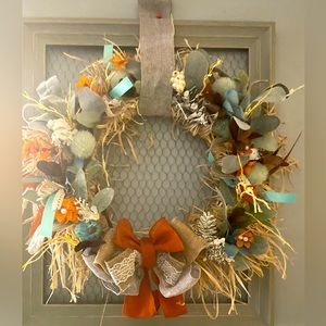 A chicken wire frame with blue,orange, tan colors